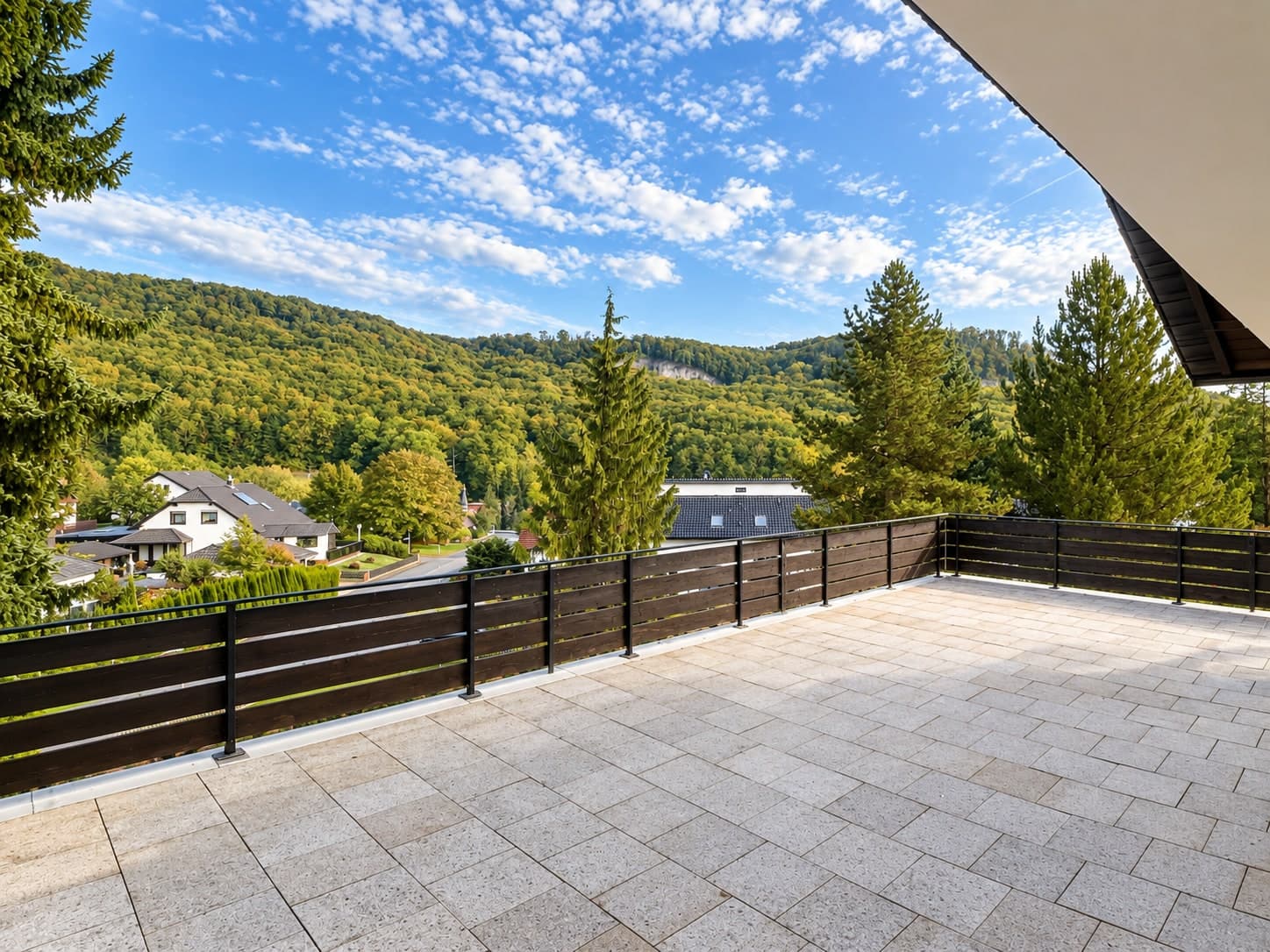 Große gepflasterte Terrasse mit Blick auf bewaldete Hügel