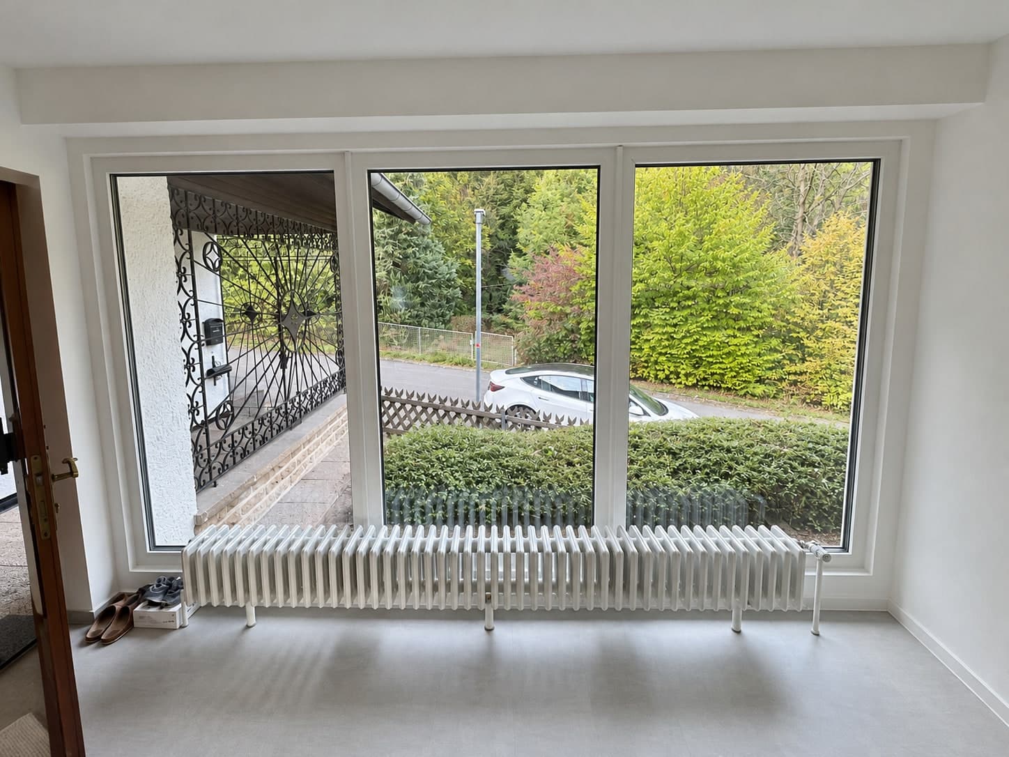 Große Fensterfront mit weißem Heizkörper im Eingangsbereich